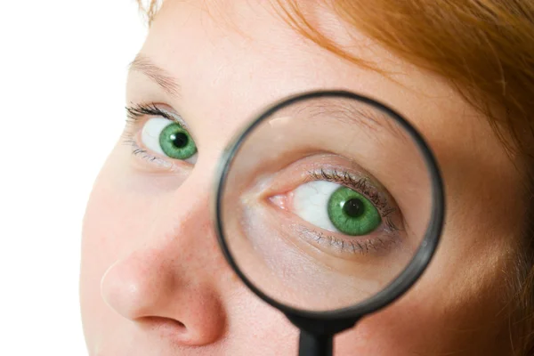 Woman's eye looking through a magnifying glass. Stock Photo