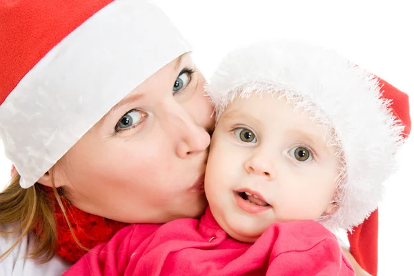 Frohe Weihnachten Mutter küsst Tochter auf weißem Hintergrund. — Stockfoto