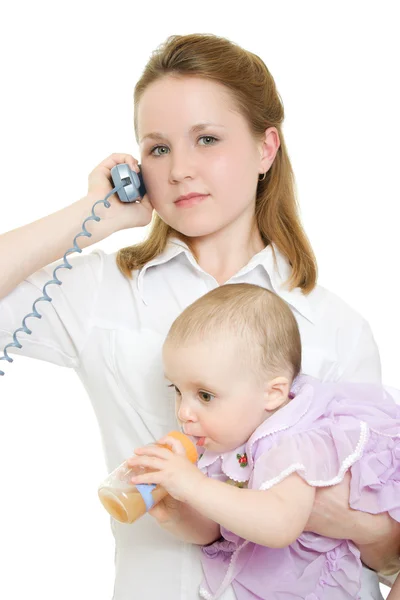 Zakenvrouw met een baby in haar armen op de telefoon. — Stockfoto