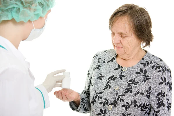 El médico toma una botella de pastillas a la anciana. . —  Fotos de Stock