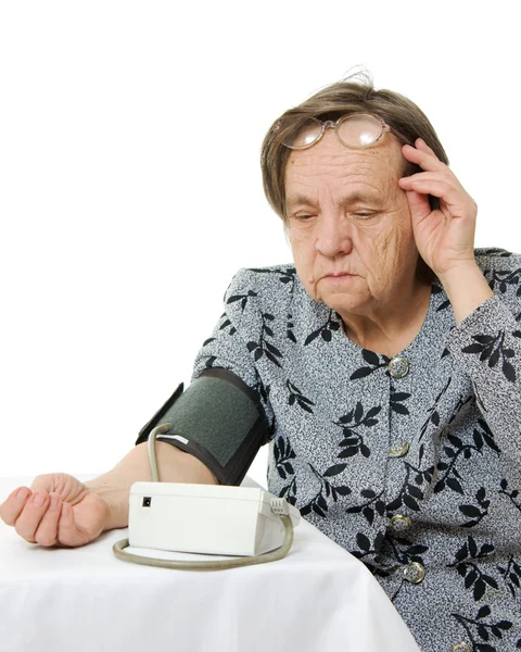 An elderly woman with a sphygmomanometer on a white background. — Stock Photo, Image
