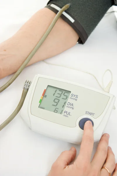 白い背景に血圧計と高齢者の女性を手します。. — ストック写真