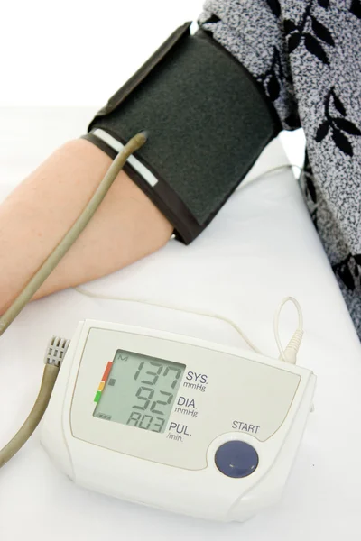 白い背景に血圧計と高齢者の女性を手します。. — ストック写真