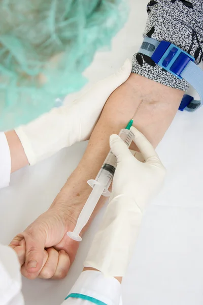 La enfermera pincha la jeringa inyectable en la mano . —  Fotos de Stock