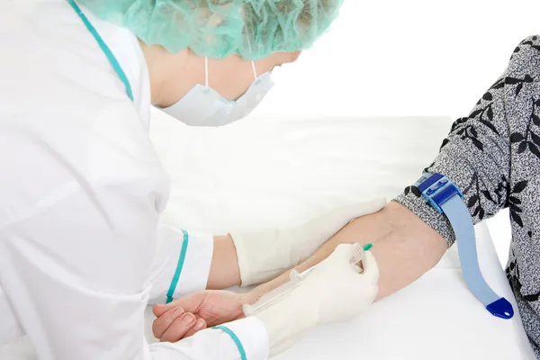 A enfermeira pica a seringa para injectáveis na mão . — Fotografia de Stock