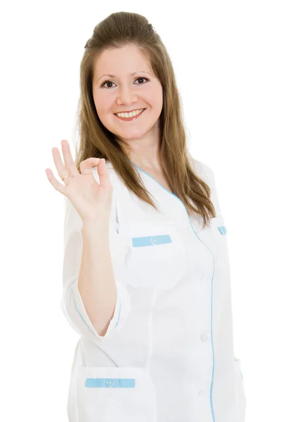 Médica mostra tudo bem com sorrisos em um fundo branco . — Fotografia de Stock