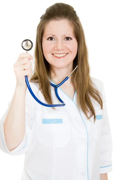 Médica sorrindo com estetoscópio na mão sobre fundo branco . — Fotografia de Stock