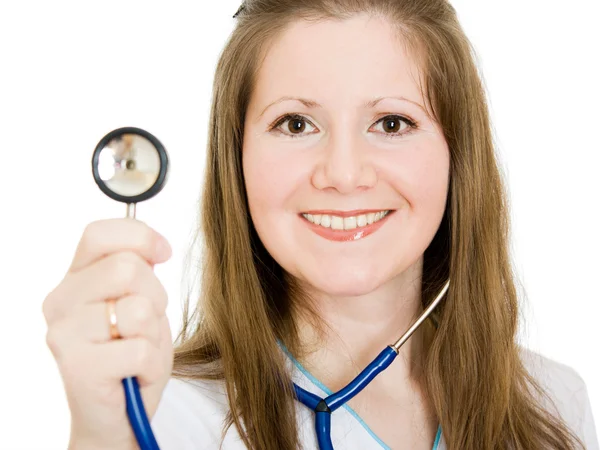Vrouwelijke arts lachend met stethoscoop in hand op witte achtergrond. — Stockfoto
