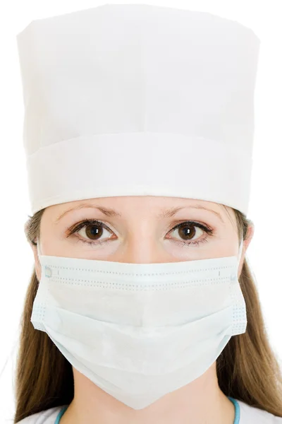 Γυναίκα γιατρός φοράει μια μάσκα και καπέλο, σε λευκό φόντο. — Φωτογραφία Αρχείου