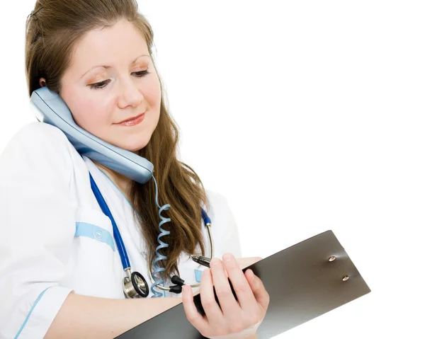 Médecin féminin parlant au téléphone et écrivant sur la plaque de document sur un w — Photo