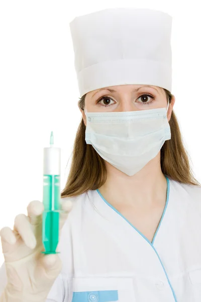 Kvinna sjuksköterska med spruta i handen på en vit bakgrund. — Stockfoto