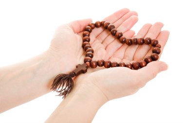 A girl holds a rosary in his hands on a white background. clipart