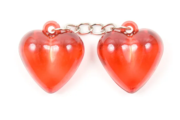 Dos corazones rojos unidos por una cadena sobre un fondo blanco . — Foto de Stock