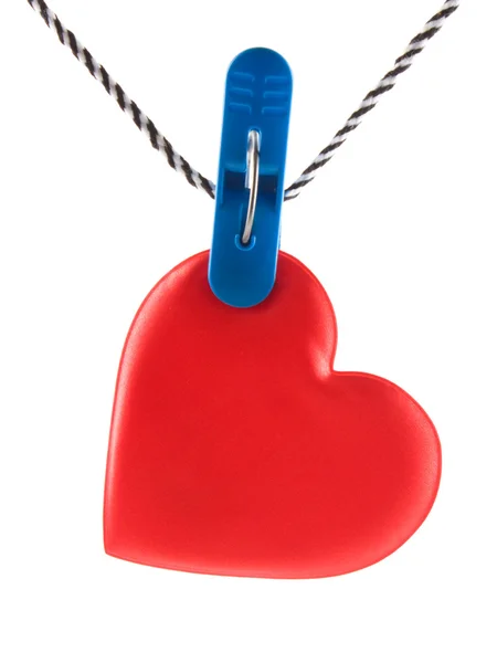 Coeur suspendu sur des pinces à linge sur une corde sur un fond blanc . — Photo