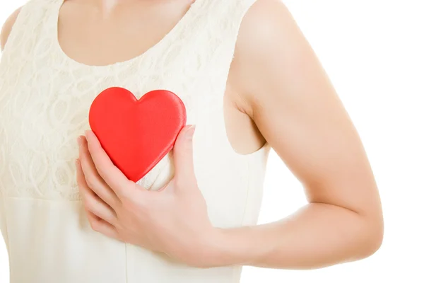 The girl pushes the heart to the chest on a white background. — Stock Photo, Image