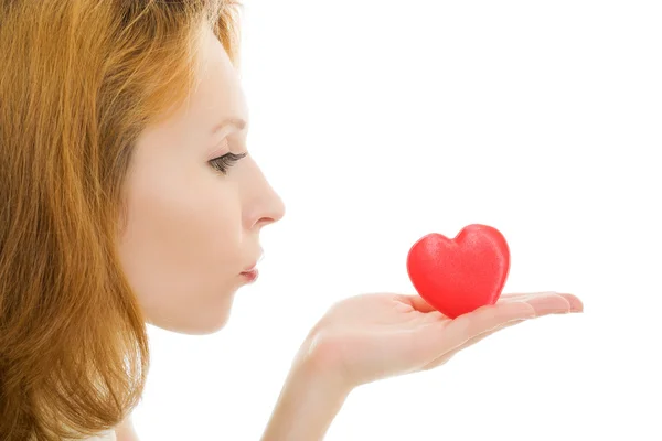 Het meisje stuurt een kus lucht in de vorm van hart op een witte achtergrond. — Stockfoto