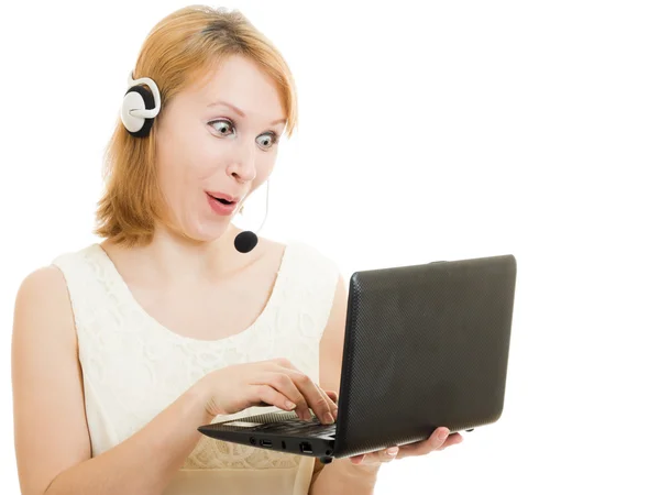 Förvånad kvinna operatör med en laptop och hörlurar. — Stockfoto