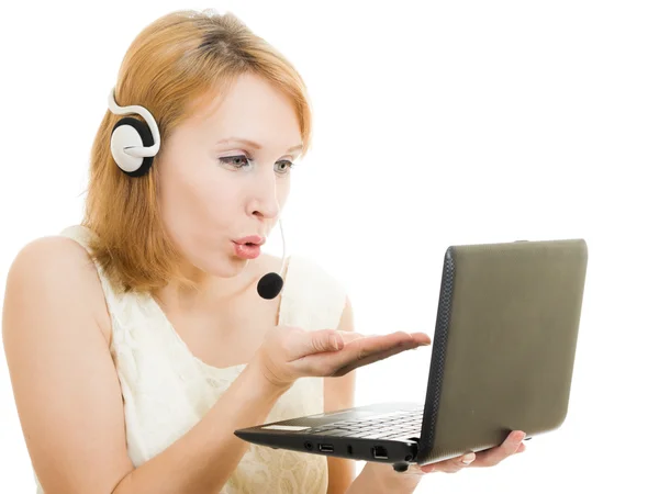 Nő telefonközpontos küld egy csók, egy laptop és fejhallgató. — Stock Fotó