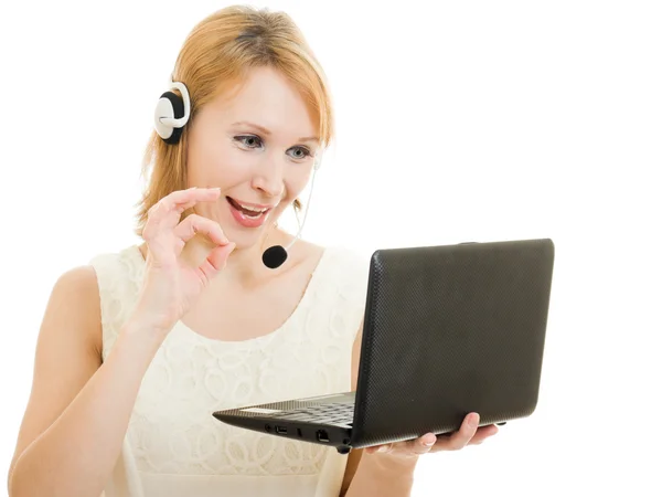 The friendly woman operator displays okay with a laptop and headphones. — Stock Photo, Image