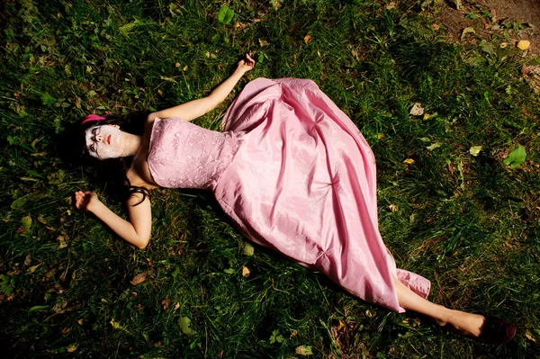 Девочка лежит на траве, как труп — стоковое фото
