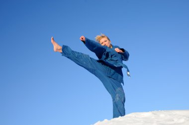 Young woman does combat sports on the snow clipart