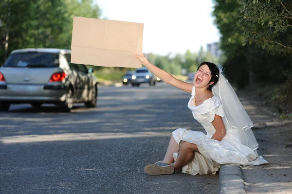Beautiful screaming bride with a blank billboard — Stock Photo, Image