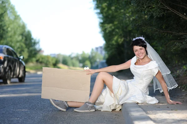 Beautiful bride with a blank billboard — Stock Photo, Image