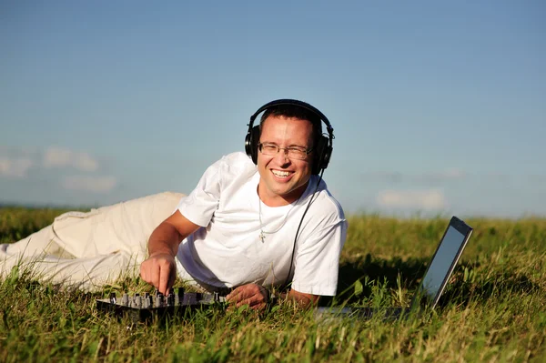 微笑在绿色草地上的唱片骑师 — 图库照片
