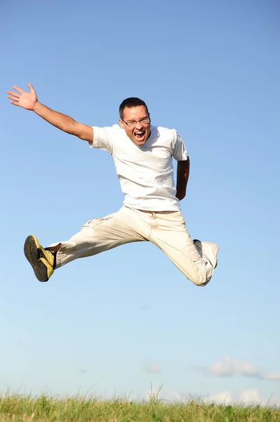 Hombre saltando en el campo verde — Foto de Stock