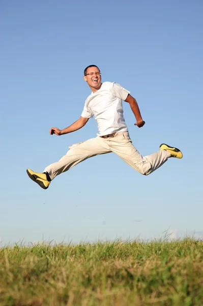 Mann springt auf grüne Wiese — Stockfoto