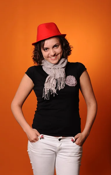 赤い帽子に笑みを浮かべてブルネットの女性 — ストック写真