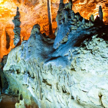 Cave stalactites and formations and a caver clipart