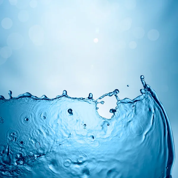 Voda splash na modrém pozadí — Stock fotografie