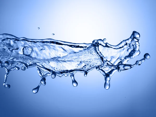 Wasserspritzer auf blauem Hintergrund — Stockfoto