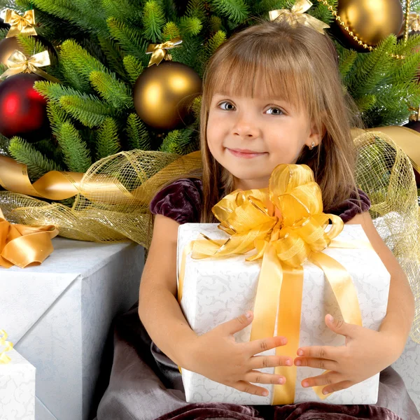 Pretty girl with present near the Cristmas tree — Stock Photo, Image