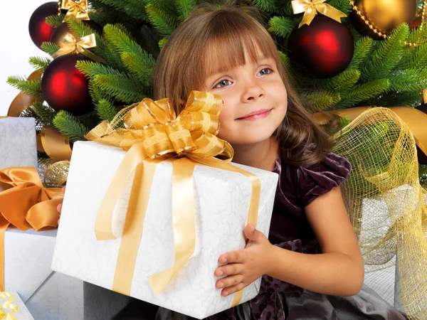Hübsches Mädchen mit Geschenk in der Nähe des Weihnachtsbaums — Stockfoto