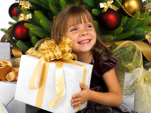 Pretty girl with present near the Christmas tree — Stockfoto