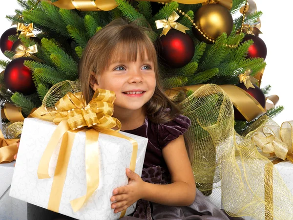 Pretty girl with present near the Christmas tree — Stockfoto