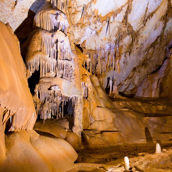 Cave stalactites and formations and a caver — Stock Photo, Image