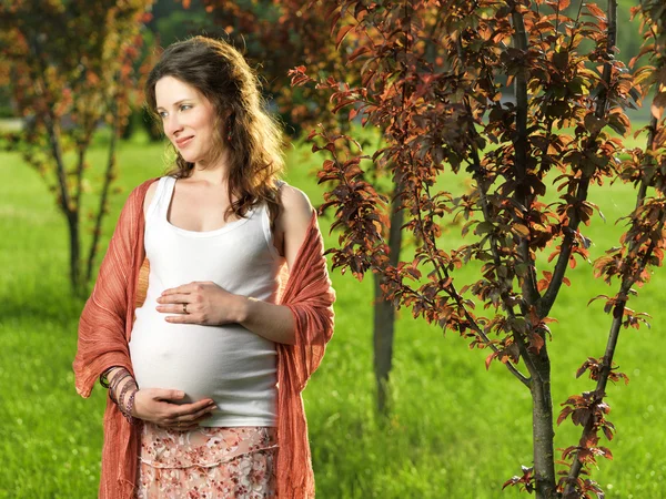 Gravid kvinna i park Royaltyfria Stockbilder
