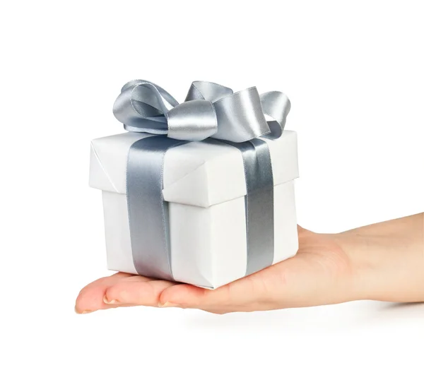 Caja de regalo con cinta de plata en la mano — Foto de Stock