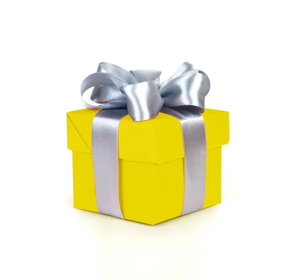 Yellow gift box with silver ribbon and bow — Stock Photo, Image