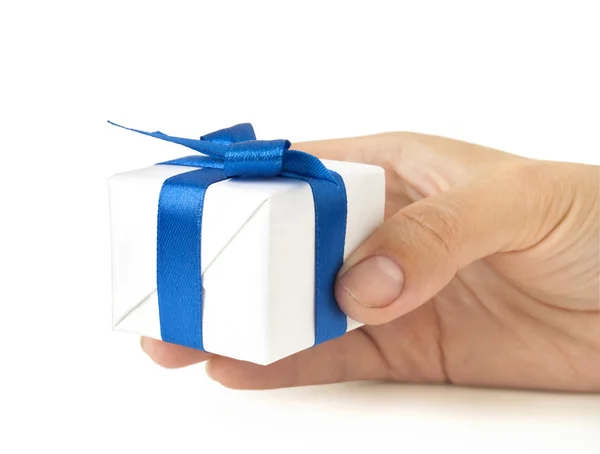 Подарункова коробка з синьою стрічкою в руці — стокове фото