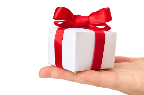 Подарочная коробка с красной лентой в руке — стоковое фото