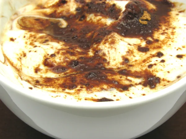 Joghurt mit Schokolade in einer Schüssel mit Porzellan bemehlt — Stockfoto
