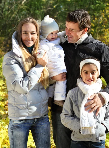 Jovem família feliz na floresta de outono — Fotografia de Stock