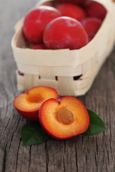 Fresh red plums on wooden background — Stock Photo, Image