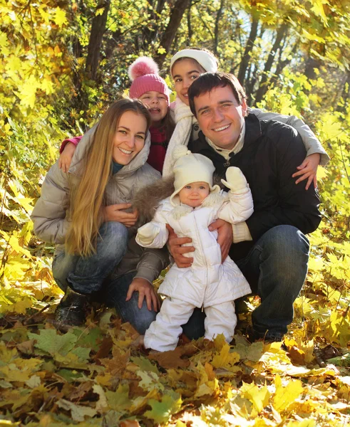 Young happy family in autumn forest — Stock Photo, Image