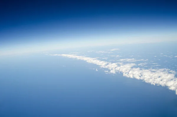 Boven de aarde op de wolken hieronder bekijken — Stockfoto
