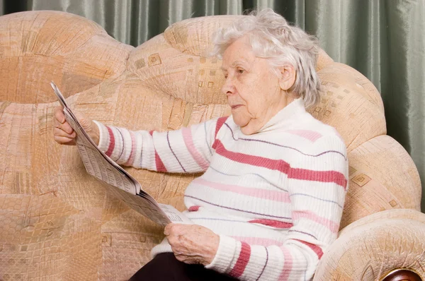 The elderly woman reads newspaper — Stock Photo, Image
